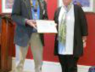Julie Large with the award presented by President John